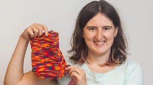 A woman is knitting tiny sweaters for her chickens to wear in winter