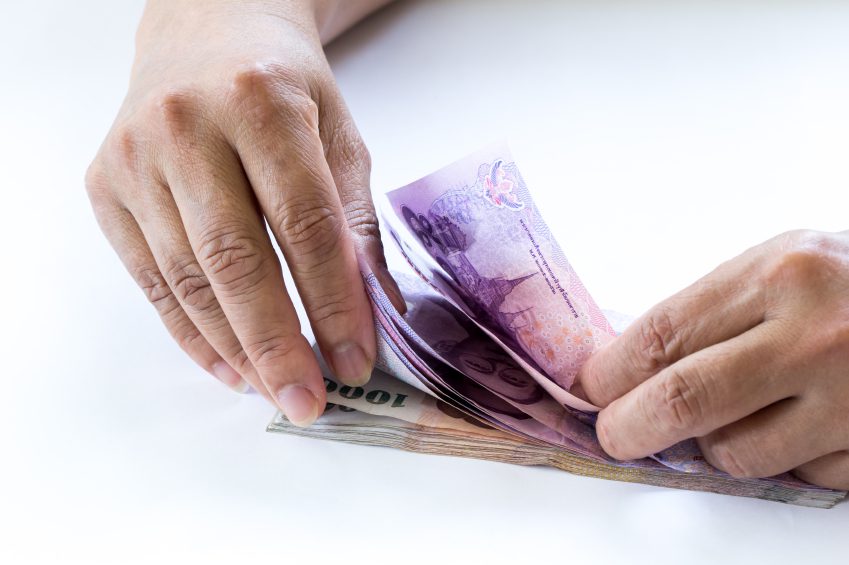 Woman hand counting Thailand money banknotes on white background
