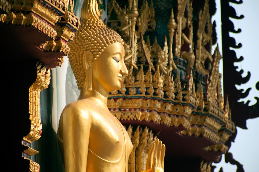 Standing Buddha front of Church on Thai temple in Thailand.