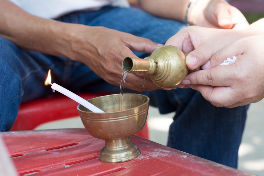 Buddhist's man and woman hand ibation grail pouring water